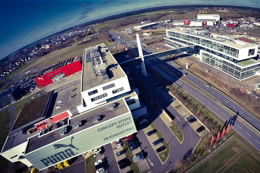 Das neue PUMAVision II (rechts im Bild) erfüllt die gleichen hohen Umwelt-standards wie das PUMAVision Headquarter (links im Bild): Moderne Betonkern-Temperaturregelung sorgt in Verbindung mit Luft-Wasser-Wärmepumpen für eine nachhaltige Beheizung und Kühlung. Eine Regenwassernutzungsanlage stellt den Großteil des Spülwassers bereit. Quelle: Maximilian Maug/PUMA
