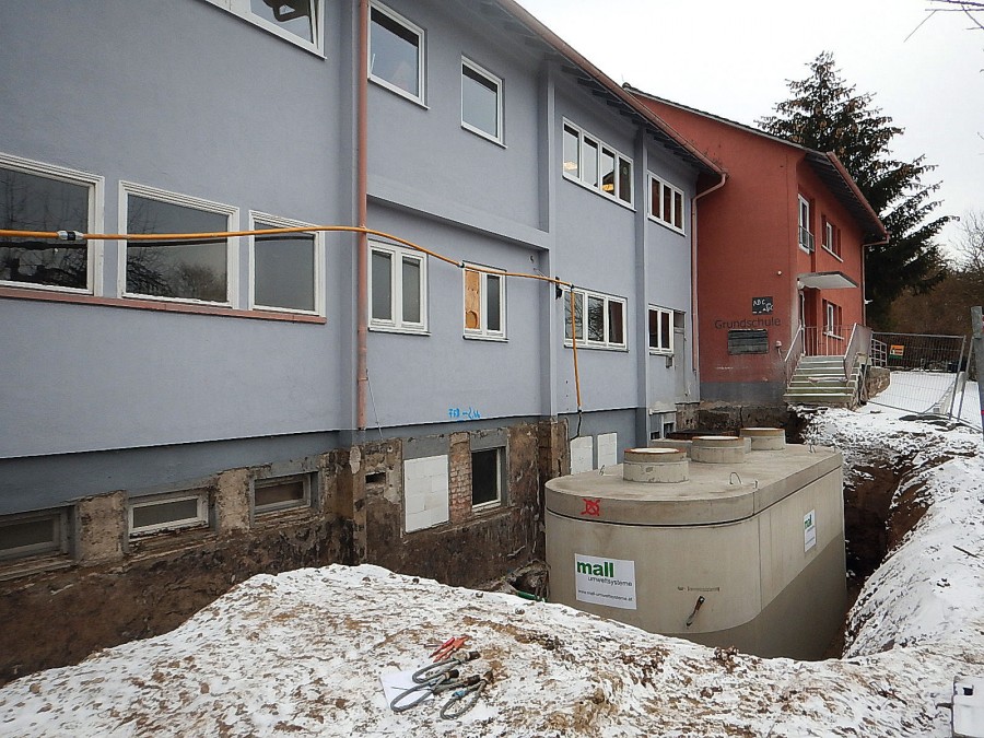 Schlossberghalle Niedereschach. Einbau des neuen Pelletspeichers unter beengten Verhältnissen auf der Nordseite. Der Fertigteil-Ovalbehälter wurde per Autokran direkt vom Lieferfahrzeug an die Stelle des früheren Öltanks gesetzt. Bild: Mall