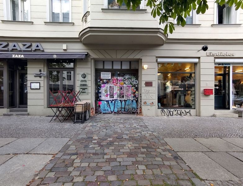 Vorderhaus der K12 mit typischer Gründerzeitfassade. Zu den Treppenaufgängen, Höfen und Quergebäuden führt ein zweiflügeliges graffitibesprühtes Eingangstor. Bild: media2business GmbH